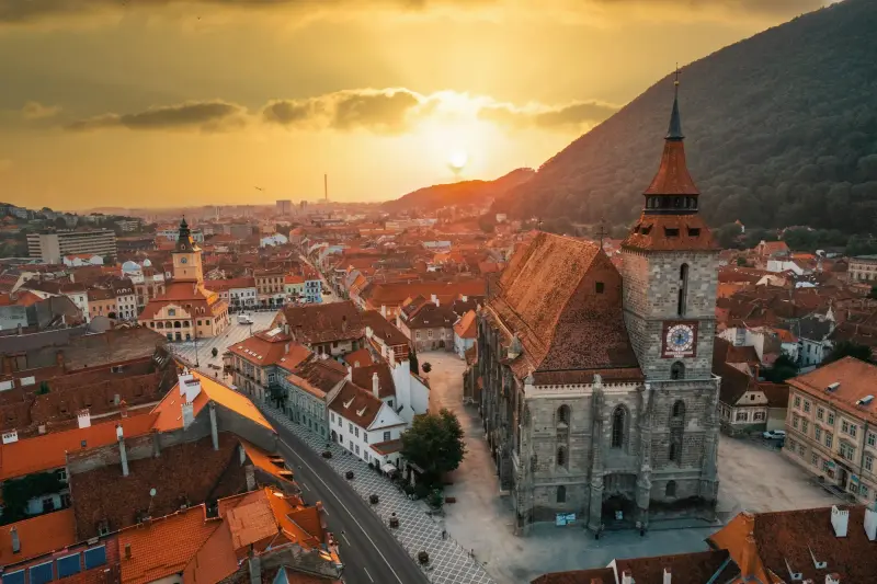 Aerial drone view black church old brasov centre sunset romania old residential buildings around it hills with greenery